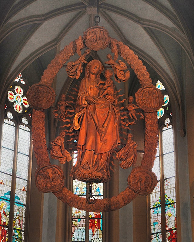 Holzskulptur, die in einem Kirchenraum hängt. Holzskulptur, die in einem Kirchenraum hängt.