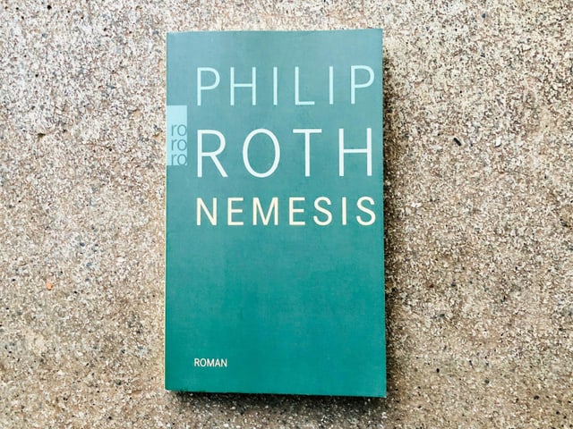 Der Roman «Nemesis» von Philip Roth liegt auf einem Zementboden Der Roman «Nemesis» von Philip Roth liegt auf einem Zementboden