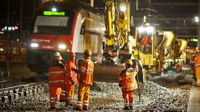 SBB-Zug fährt an Gleisbau-Arbeitern vorbei. SBB-Zug fährt an Gleisbau-Arbeitern vorbei.