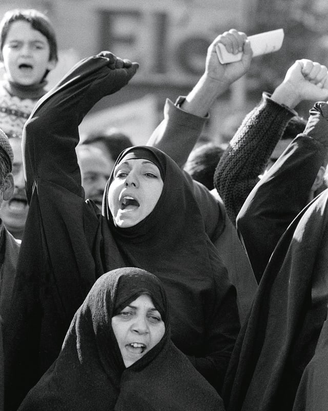 Iranische Frauen im Tschador demonstrieren mit erhobenen Fäusten. Iranische Frauen im Tschador demonstrieren mit erhobenen Fäusten.