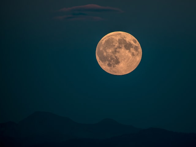 Grosse, weisse Vollmondscheibe am dunkelblauen Himmel. Der Mond scheint riesig.