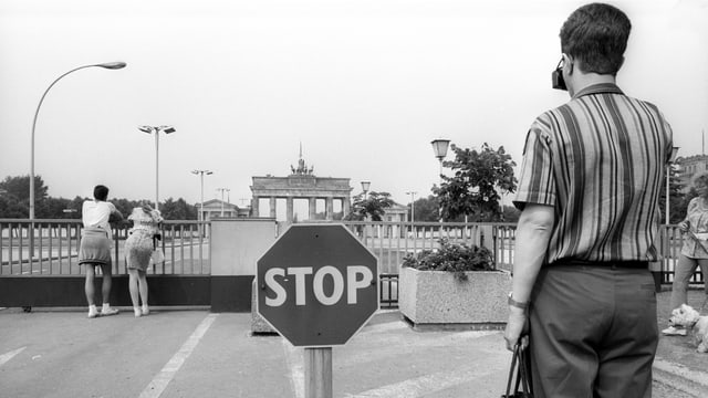 Passanten auf der Ostseite des Brandenburger Tors mit Stoppschild. Passanten auf der Ostseite des Brandenburger Tors mit Stoppschild.