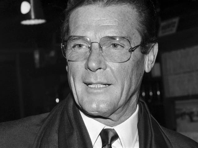 Roger Moore im Anzug mit Brille. Roger Moore im Anzug mit Brille.