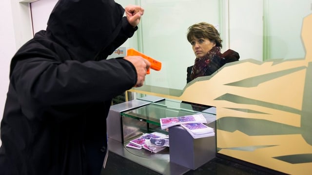 Mann bededroht Bankangestellte mit Pistole Mann bededroht Bankangestellte mit Pistole