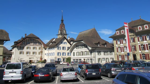 Ein Platz mit vielen Autos und Parkplätzen Ein Platz mit vielen Autos und Parkplätzen