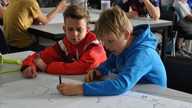 Schüler zeichnen am Pult Schüler zeichnen am Pult