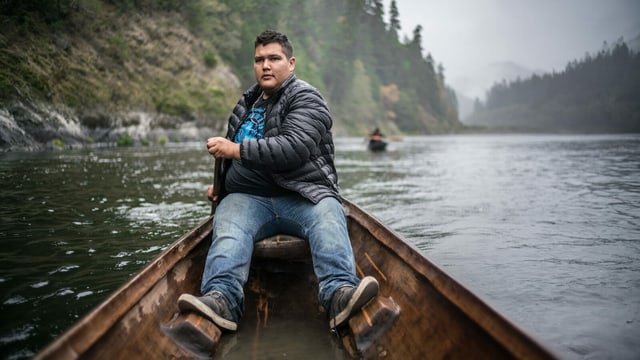 Ein junger Mann sitzt in einem Kanu auf einem Fluss. Ein junger Mann sitzt in einem Kanu auf einem Fluss.