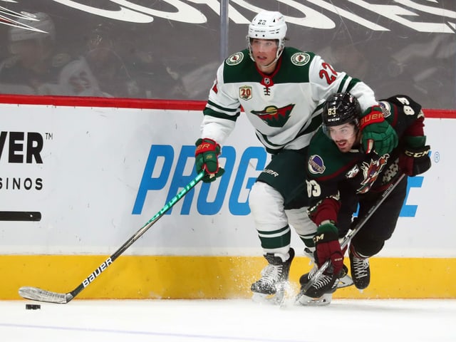 Kevin Fiala hat im Zweikampf mit Conor Garland an der Bande den Puck. Kevin Fiala hat im Zweikampf mit Conor Garland an der Bande den Puck.