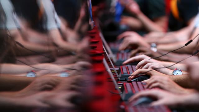 Hände an den Tastaturen aufgereihter PCs. Hände an den Tastaturen aufgereihter PCs.