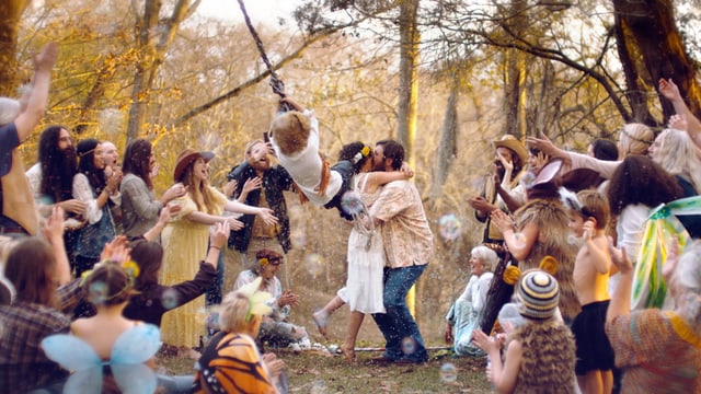 Heiratendes Hippie-Paar, umringt von einer applaudierenden Menschenmenge Heiratendes Hippie-Paar, umringt von einer applaudierenden Menschenmenge