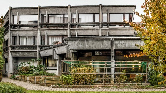 Eine Fassadenfront eines Altersheimes: Zweistöckies Gebäude mit grossen Fenster in weinroten Fensterrahmen. Das Gebäude selbst ist aus Beton, an welchem viele Witterungsspuren in Form von schwarzen Verfärbungen zu sehen ist. Eine Fassadenfront eines Altersheimes: Zweistöckies Gebäude mit grossen Fenster in weinroten Fensterrahmen. Das Gebäude selbst ist aus Beton, an welchem viele Witterungsspuren in Form von schwarzen Verfärbungen zu sehen ist.