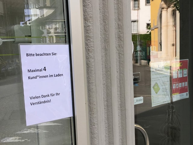 Schild am Eingang zur Buchhandlung: "Maximal 4 Kund*innen im Laden" Schild am Eingang zur Buchhandlung: "Maximal 4 Kund*innen im Laden"