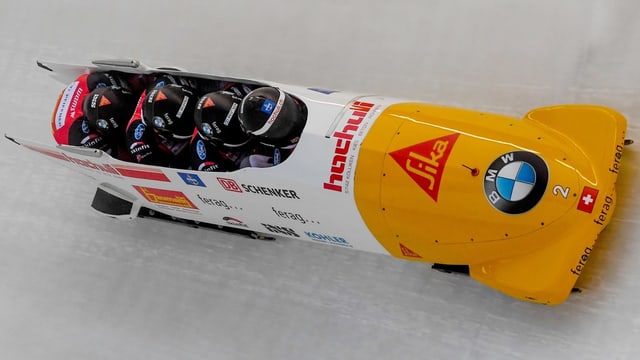 Vier Bobfahrer in einem gelbweissen Bob. Vier Bobfahrer in einem gelbweissen Bob.