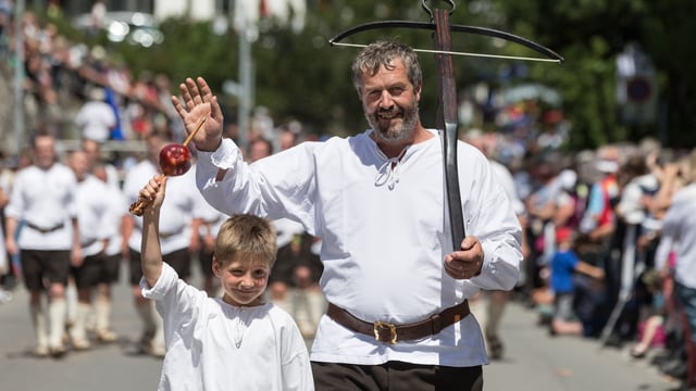 Mann als Wilhelm Tell verkleidet mit Walterli, seinem Sohn Mann als Wilhelm Tell verkleidet mit Walterli, seinem Sohn