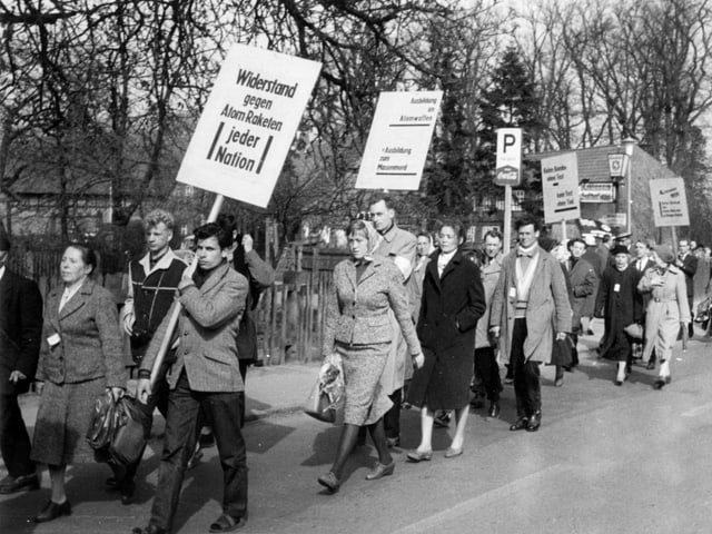 Menschen mit Schildern protestieren Menschen mit Schildern protestieren