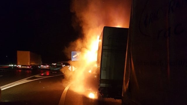 Ein brennender Lieferwagen bei einer Autobahnausfahrt. Es ist noch dunkel. Ein brennender Lieferwagen bei einer Autobahnausfahrt. Es ist noch dunkel.