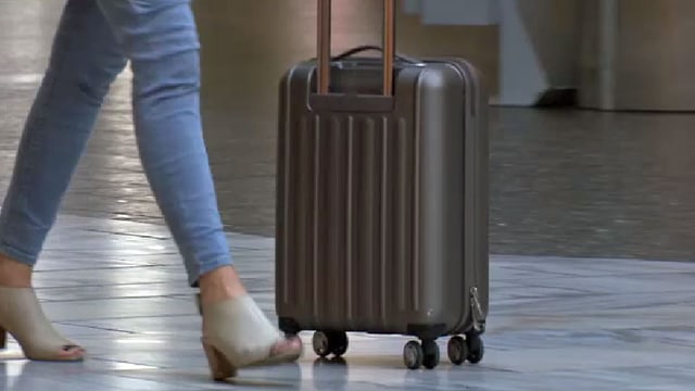Frau schiebt Rollkoffer. Frau schiebt Rollkoffer.