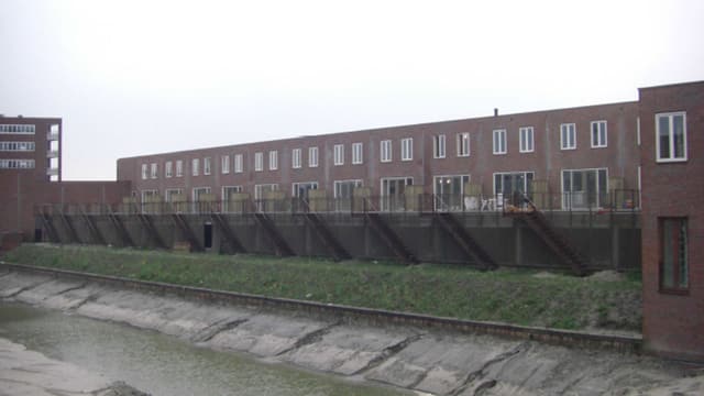 Ein flaches Mehrfamilienhaus aus rotem Backstein, mit weissen Fensterrahmen Ein flaches Mehrfamilienhaus aus rotem Backstein, mit weissen Fensterrahmen