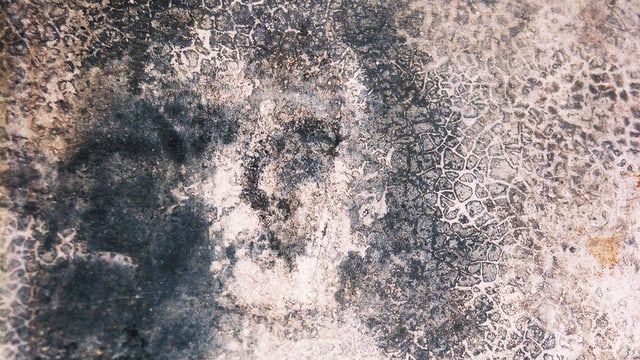 Undeutliche dunkle Flecken auf der Wand, die entfernt an ein Gesicht erinnern. Undeutliche dunkle Flecken auf der Wand, die entfernt an ein Gesicht erinnern.