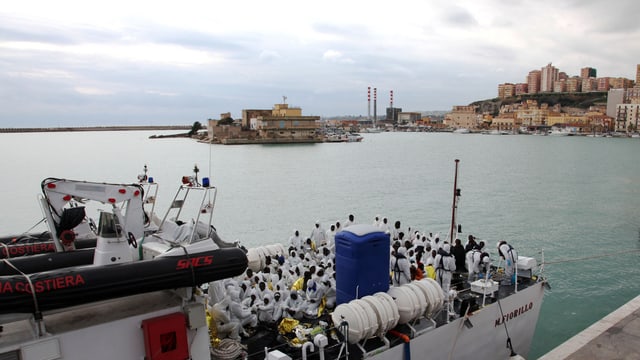 Flüchtlinge auf einem Schiff der italienischen Küstenwache. Flüchtlinge auf einem Schiff der italienischen Küstenwache.