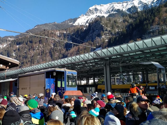 Perron voll mit Menschen, die Sonne scheint