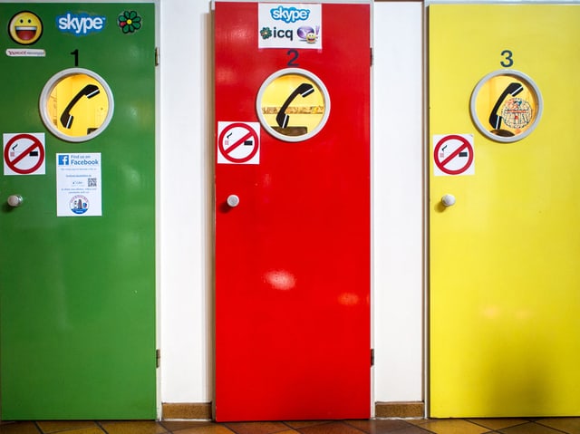 Grüne, rote und gelbe Telefonkabine in einer Reihe. Grüne, rote und gelbe Telefonkabine in einer Reihe.