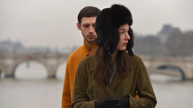 Ein Mann und eine Frau stehen auf einer Brücke in Paris. Ein Mann und eine Frau stehen auf einer Brücke in Paris.