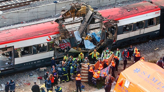 Zerstörter Zug, Rettungskräfte im Vordergrund Zerstörter Zug, Rettungskräfte im Vordergrund