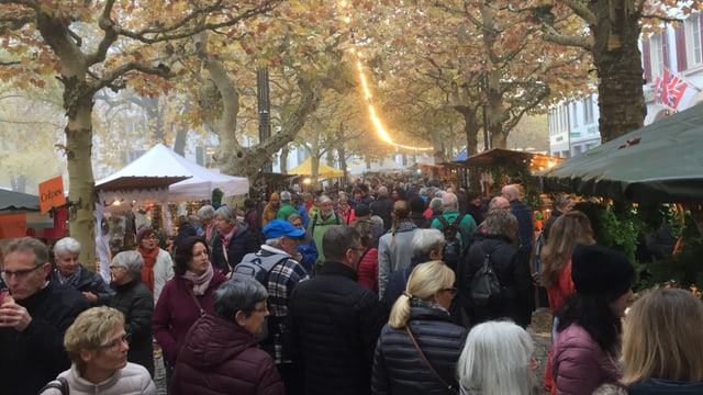 Leute an Marktständen Leute an Marktständen