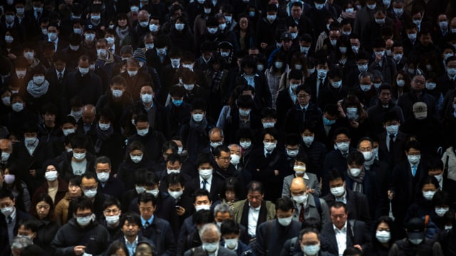Menschenmasse, alle tragen Gesichtsmasken. Menschenmasse, alle tragen Gesichtsmasken.