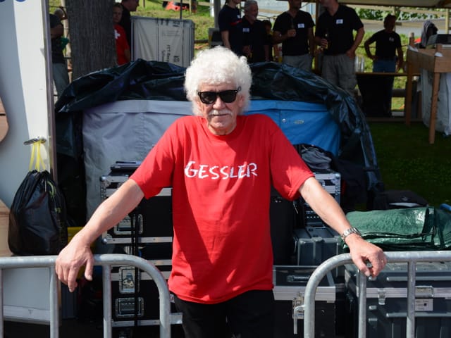 Mann mit rotem Shirt auf dem Gessler steht.