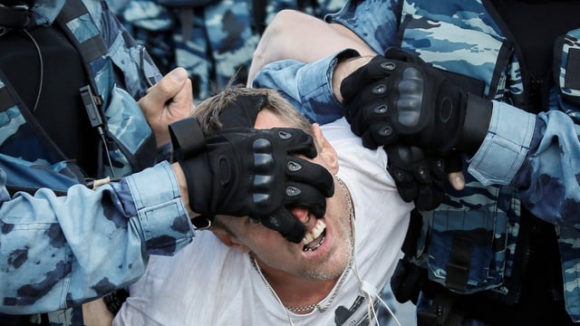 Protestierende wird von Polizisten festgehalten Protestierende wird von Polizisten festgehalten