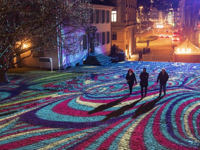 Beleuchteter Platz mit psychodelischem Muster.