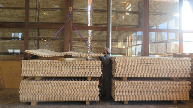 Zwei Stapel Holz, Kran transportiert Holz. Zwei Stapel Holz, Kran transportiert Holz.