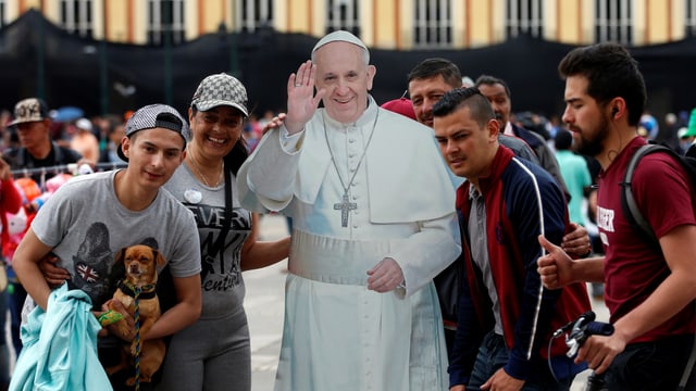 Junge Kolumbianer gruppieren sich um ein mannshohes Abbild aus Karton des Papstes. Junge Kolumbianer gruppieren sich um ein mannshohes Abbild aus Karton des Papstes.