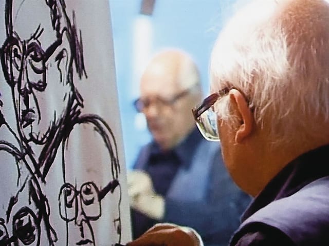 Friedrich Dürrenmatt wird gespiegelt fotografiert, wie er ein Selbstporträt zeichnet. Friedrich Dürrenmatt wird gespiegelt fotografiert, wie er ein Selbstporträt zeichnet.