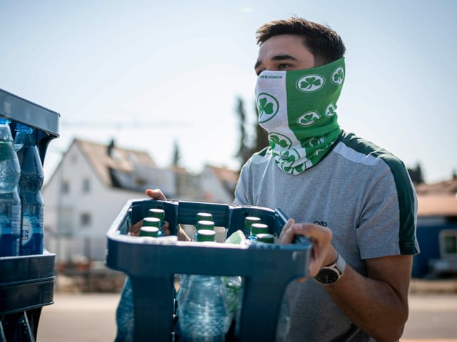 Die Spieler von Greuther Fürth verteilen Getränkekisten.