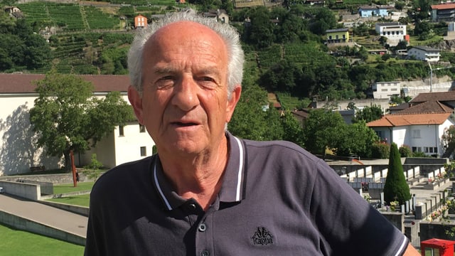 Ein älterer Mann mit grauem Haar, im Hintergrund eine alte Kirche. Ein älterer Mann mit grauem Haar, im Hintergrund eine alte Kirche.