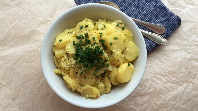 Eine Schale mit ganz klassisch gemachtem Badischem Kartoffelsalat mit viel Schnittlauch und Salatgurken-Würfeli. Eine Schale mit ganz klassisch gemachtem Badischem Kartoffelsalat mit viel Schnittlauch und Salatgurken-Würfeli.