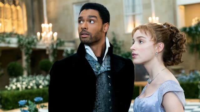 Junger schwarzer Mann neben junger weisser Frau: Szene aus der Netflix-Serie Bridgerton. Junger schwarzer Mann neben junger weisser Frau: Szene aus der Netflix-Serie Bridgerton.