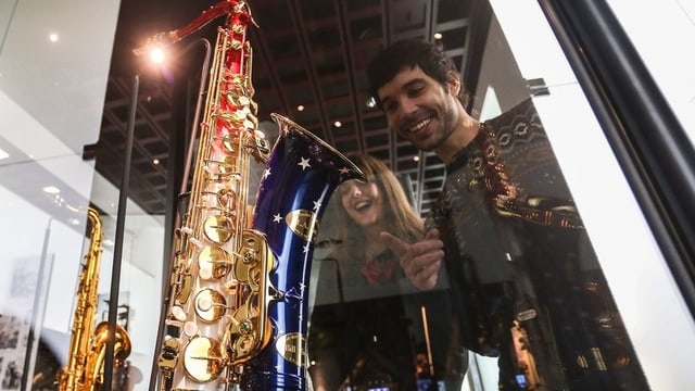 Besucher einer Saxofon-Ausstellung bewundern Exponate Besucher einer Saxofon-Ausstellung bewundern Exponate