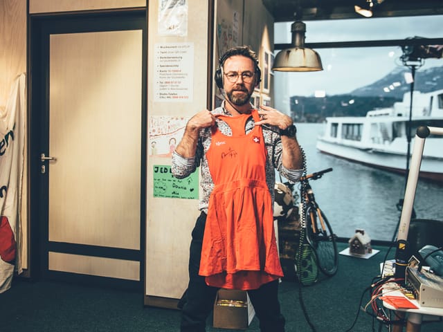 Nik, der ein Kleid vor sich hält