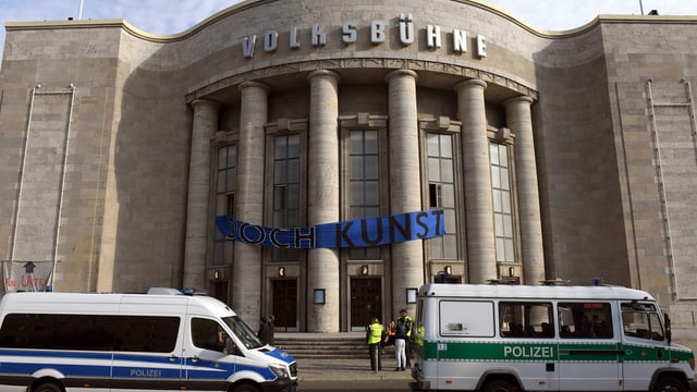 Vor der Berliner Volksbühne stehen Polizei-Autos. Vor der Berliner Volksbühne stehen Polizei-Autos.