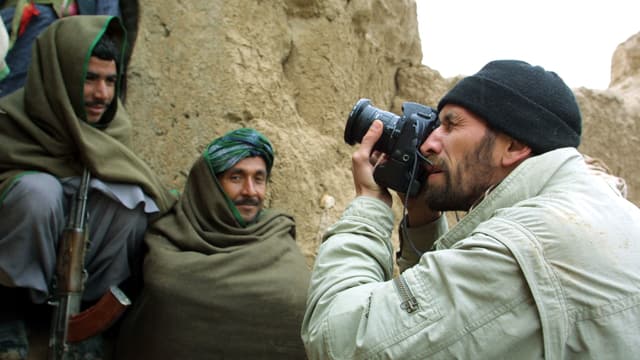 Ein Fotograf macht Nahaufnahmen von bewaffneten Männern. Ein Fotograf macht Nahaufnahmen von bewaffneten Männern.