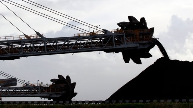 Eine Maschine bewegt Kohle in einer Mine in Australien. Eine Maschine bewegt Kohle in einer Mine in Australien.