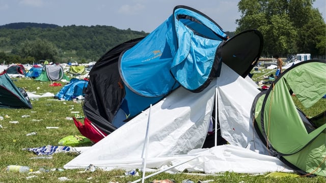 Liegengebliebene Zelte auf einem Festivalgelände Liegengebliebene Zelte auf einem Festivalgelände