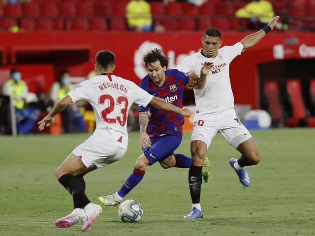 Lionel Messi wird von Sevillas Sergio Reguilon und Diego Carlos ins Sandwich genommen. Lionel Messi wird von Sevillas Sergio Reguilon und Diego Carlos ins Sandwich genommen.
