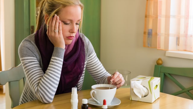 Eine erkältete Frau trinkt einen Tee Eine erkältete Frau trinkt einen Tee
