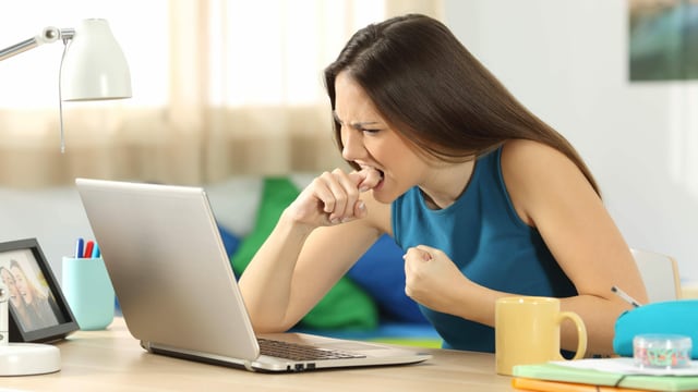 Eine Frau ärgert sich vor ihrem Laptop