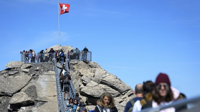 Touristen gehen über die Hängebrücke im Diablerets-Massiv der Berner Alpen. Touristen gehen über die Hängebrücke im Diablerets-Massiv der Berner Alpen.